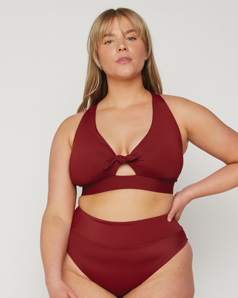 Front of a model wearing a size 34C, 34D Dottie Tie Bikini Top in Ruby by Wild Isles. | dia_product_style_image_id:251684